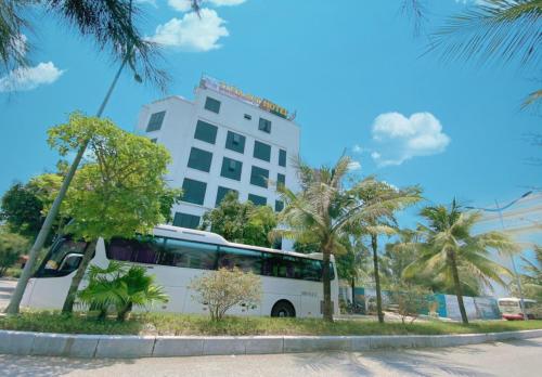 岑山Tuấn Đạt Luxury FLC Sầm Sơn的停在大楼前的白色巴士