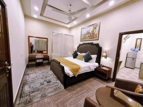 拉合尔Hayyat Luxury Apartments的一间卧室配有一张床、一张桌子和一面镜子