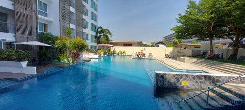 华欣Tira Tiraa Condominium的大楼内的一个蓝色海水游泳池