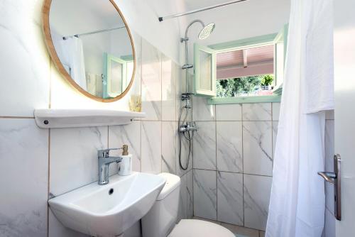 巴尔巴蒂Reana Elegant Apartments的一间带水槽、卫生间和镜子的浴室