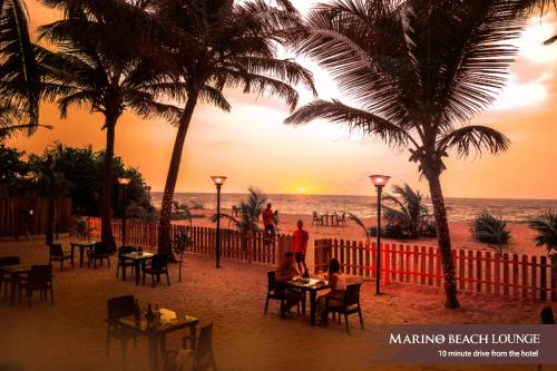 科伦坡科伦坡马里诺海滩酒店的日落时坐在海滩上桌子上的人