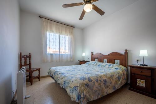 托里代巴拉AT015 Els Munts的一间卧室配有一张床和吊扇