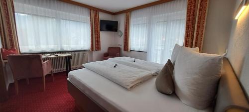 奥伯林塔尔的里德Haus Tirol Appartements的配有白色枕头的床的酒店客房