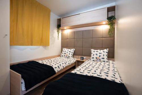 科兰Lavanda Mobile Home at Terra Park Spiritos camp的带两张床的小房间,带水电