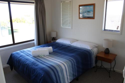 纳鲁马纳鲁马棕榈度假公寓酒店的一间卧室配有蓝色的床和两个枕头