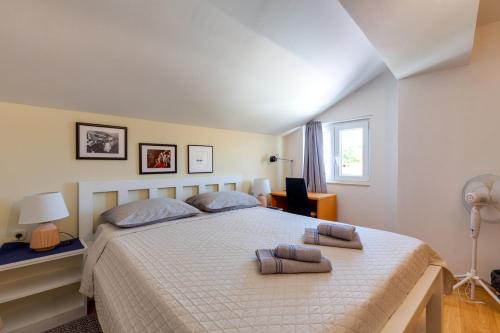木洛希尼Apartments Valeria, Mali Lošinj的一间卧室配有一张大床和两个枕头