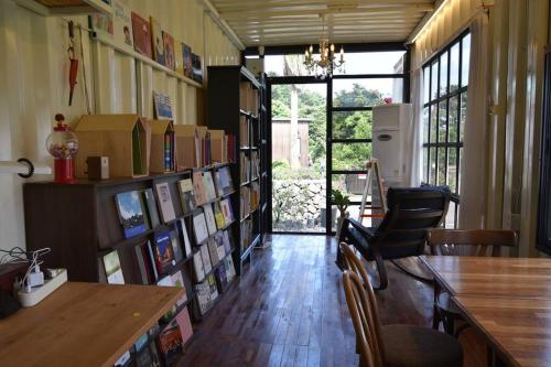 西归浦市Jo and Lee Kids House的一间设有书架和桌子的图书馆的房间