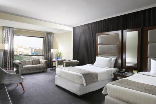 拉合尔Four Points by Sheraton Lahore的酒店客房,设有两张床和一张沙发