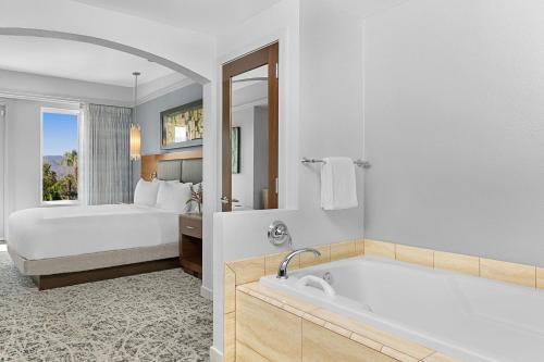 棕榈荒漠沙漠泉万豪别墅酒店的一间带床和浴缸的浴室以及一间卧室