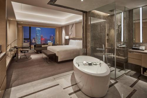 成都成都茂业JW万豪酒店的酒店客房配有一张床和浴缸。