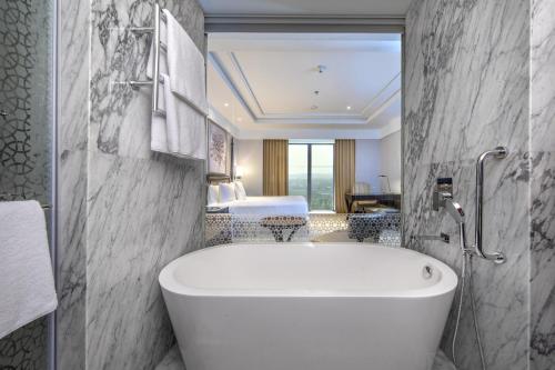 加尔各答ITC Royal Bengal, a Luxury Collection Hotel, Kolkata的带浴缸的浴室和卧室
