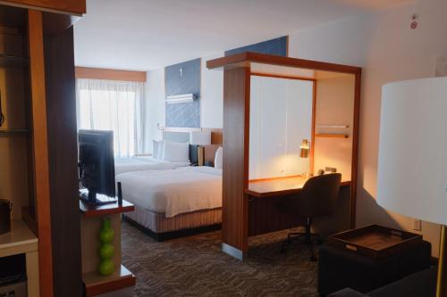 理查森达拉斯理查森/普莱诺万豪酒店的酒店客房配有一张床、一张书桌和一台电视。