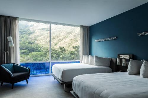 MaracayMarriott Maracay Golf Resort的酒店客房设有两张床和大窗户。