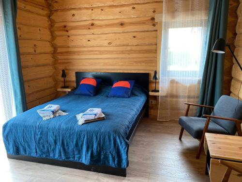 尤卡尔内Zvejnieku māja的一间卧室配有蓝色的床和蓝色和红色枕头