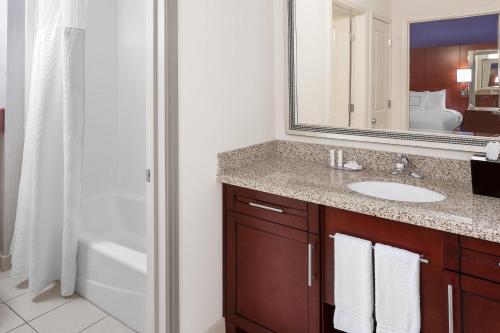 凯蒂休斯顿凯蒂米尔斯万豪原住客栈的浴室配有盥洗盆、镜子和浴缸