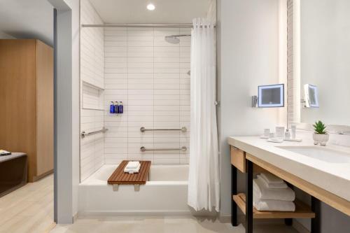 安纳海姆The Viv Hotel, Anaheim, a Tribute Portfolio Hotel的带浴缸和盥洗盆的浴室
