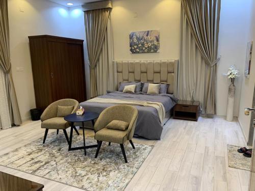 阿尔阿尔شاليه رست نايت - عرعر的一间卧室配有一张床、两把椅子和一张桌子
