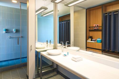 普莱诺普莱诺阿罗福特酒店的浴室设有2个水槽和2面镜子