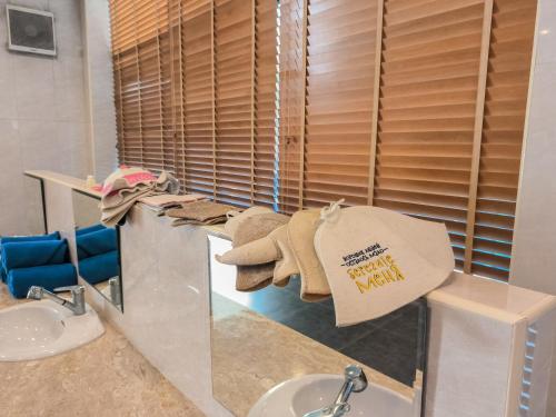 拉威海滩Rawai Grand House -SHA Plus的浴室设有水槽和柜台上的毛巾