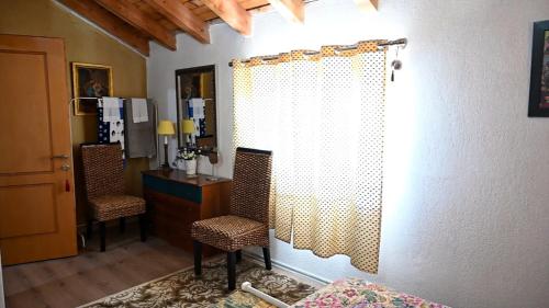 波格拉德茨Vila Topalli的一间卧室配有两把椅子、一张桌子和窗帘