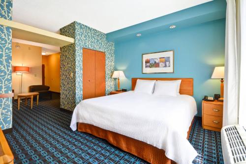 富尔顿戴尔伯明翰富尔顿戴尔/I-66费尔菲尔德万豪套房酒店的酒店客房设有一张大床和蓝色的墙壁。