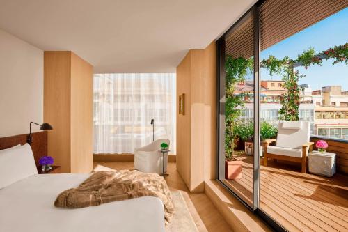 巴塞罗那巴塞罗那艾迪逊酒店的一间卧室设有一张床和一个大窗户