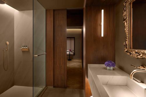 巴塞罗那巴塞罗那艾迪逊酒店的一间带水槽和玻璃淋浴的浴室