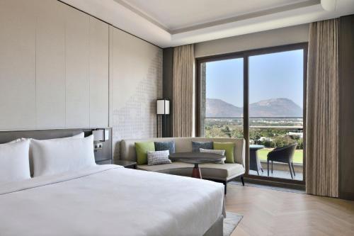 班加罗尔JW Marriott Hotel Bengaluru Prestige Golfshire Resort & Spa的酒店客房,配有床和沙发