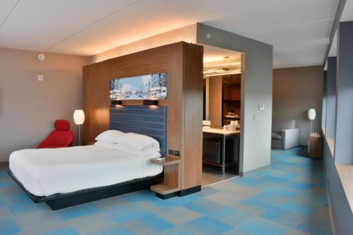 罗利雅乐轩罗利酒店的一间卧室配有一张床和一张带红色椅子的书桌