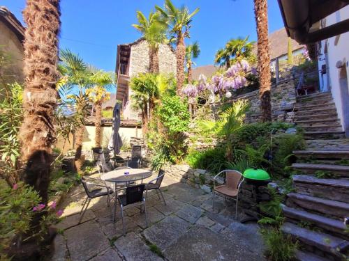 Brione sopra Minusio格里利诺之家公寓的一个带桌椅和棕榈树的庭院