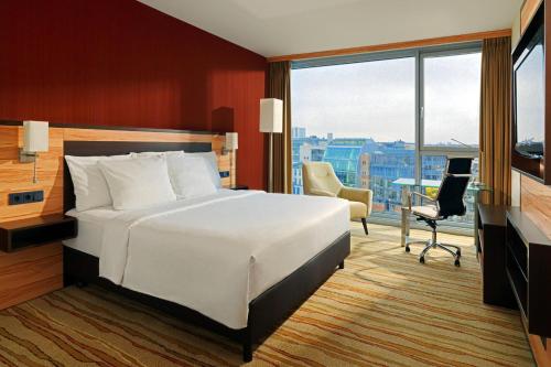 杜塞尔多夫万豪度假酒店杜塞尔多夫港店的卧室配有一张白色大床和一张书桌