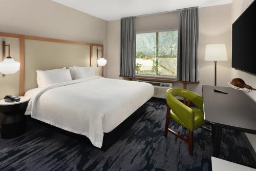 洛斯阿拉米托斯Fairfield by Marriott Inn & Suites Anaheim Los Alamitos的酒店客房设有一张大床和一张黄色椅子