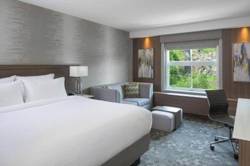 埃奇沃特万豪厄齐沃特NYC区万怡酒店的酒店的客房 - 带一张床、椅子和窗户