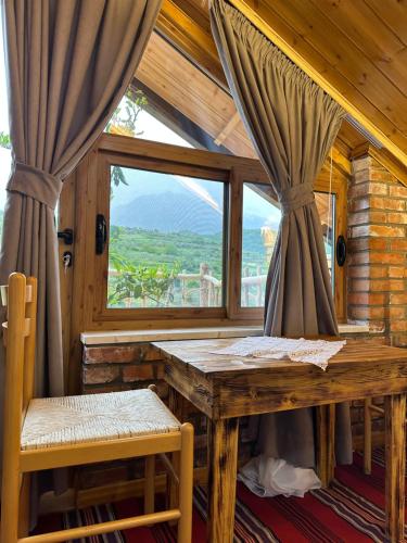 RoshnikAlpeta Agrotourism & Winery - Roshnik , Berat的一间带桌子和窗户的用餐室