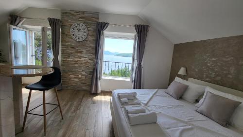 科尔丘拉Old Town Sea Front M&M Apartment Korčula的一间卧室配有一张床、一张桌子和一个窗户。