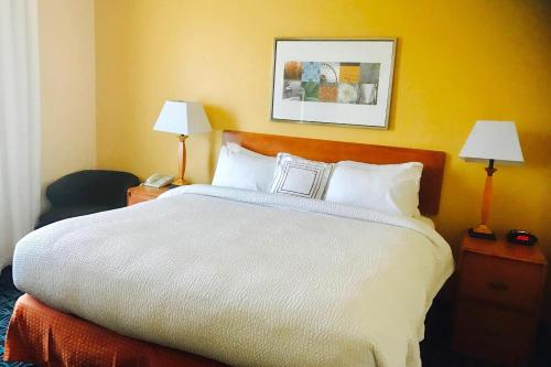 萨克拉门托费尔菲尔德纳特欧玛斯萨克拉门托机场套房旅馆的酒店客房设有一张大床和两盏灯。