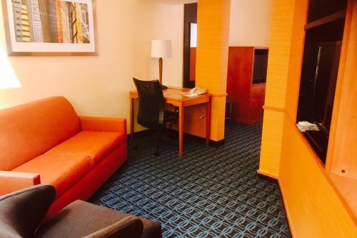 萨克拉门托费尔菲尔德纳特欧玛斯萨克拉门托机场套房旅馆的酒店客房设有沙发、书桌和电脑
