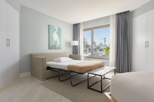 棕榈滩Courtyard by Marriott Aruba Resort的一间卧室设有一张床和一个大窗户