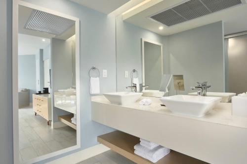 棕榈滩Courtyard by Marriott Aruba Resort的一间带两个盥洗盆和大镜子的浴室