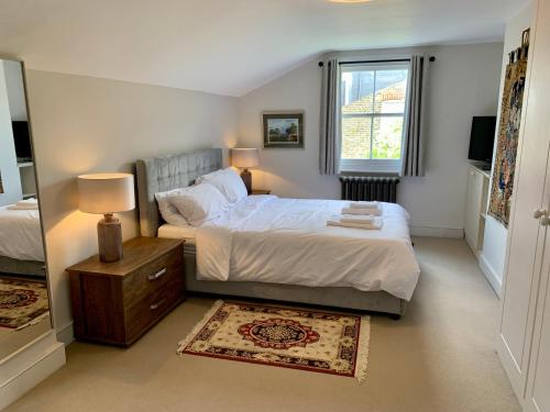 伦敦Lovely newly refurbished apartment in Battersea的一间卧室设有一张大床和一个窗户。