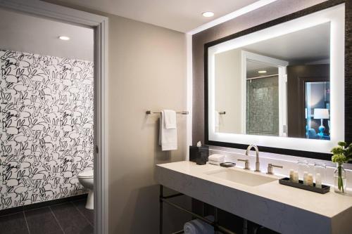 查尔斯顿The Lindy Renaissance Charleston Hotel的一间带水槽、镜子和卫生间的浴室