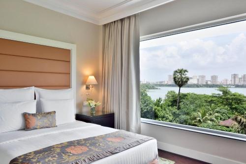 孟买Marriott Executive Apartment - Lakeside Chalet, Mumbai的一间卧室设有一张床和一个大窗户