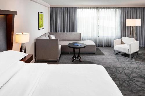 布卢明顿布卢明顿喜来登酒店的酒店客房配有床、沙发和椅子
