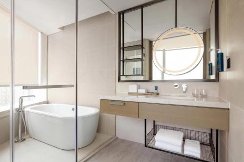 香港香港东涌福朋喜来登酒店的带浴缸、水槽和镜子的浴室