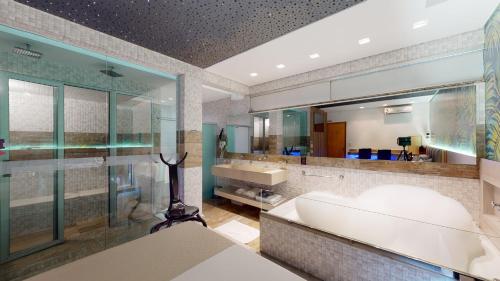贝洛奥里藏特Motel DUBAI BH的一间带浴缸和大镜子的浴室
