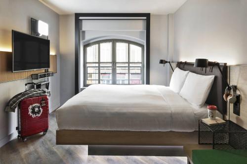 里尔Moxy Lille City的一间卧室设有一张大床和一个窗户。