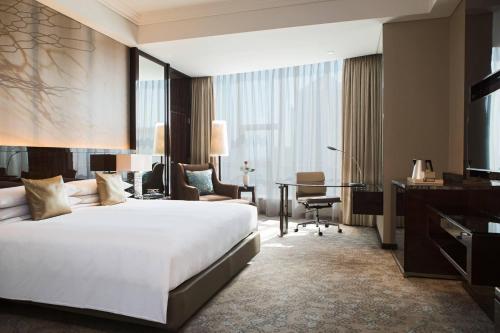 上海上海淳大万丽酒店的酒店客房设有一张大床和一张书桌。
