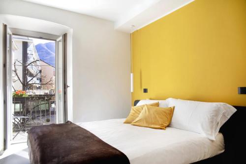 多莫多索拉Ca Bussun的卧室配有白色床和黄色墙