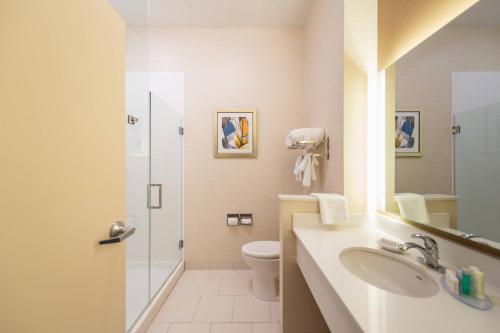 悉尼西德尼费尔菲尔德酒店及套房的浴室配有卫生间、盥洗盆和淋浴。