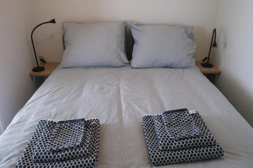 海滨诺德韦克Seepaertje 2的一张带两个枕头和两个篮子的床